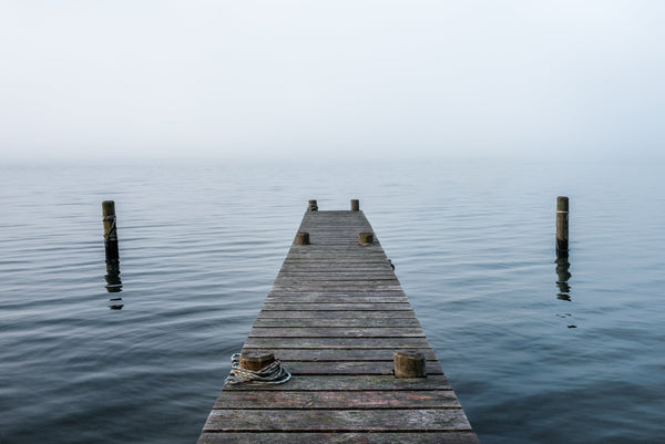 A lone jetty stretches out into the waters of Frankton Arm, Lake Wakatipu near Queenstown in early morning mist.