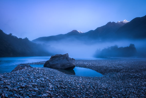 Mist builds in the late evening over the waters of the Haast River, West Coast