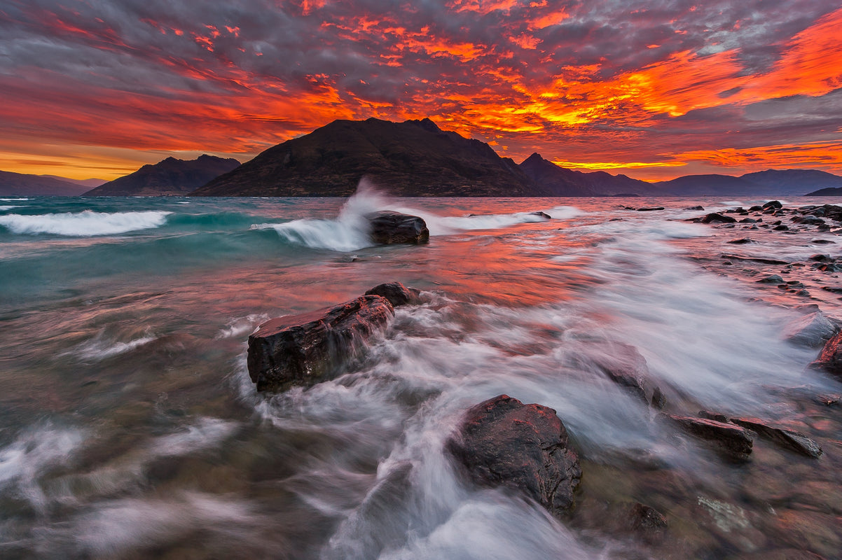 A blazing red sunset behind Cecil and Walter Peaks near Queenstown.  Taken in the summer months, as stormy weather whips up waves on the shores of Lake Wakatipu.  I love these times when several natural events align creating something truly memorable.