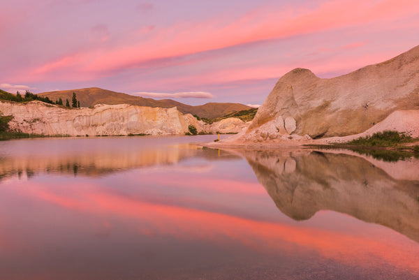 A perfectly calm morning at the Blue Lake, St Bathans as the morning sky lights up pink with a beautiful sunrise.