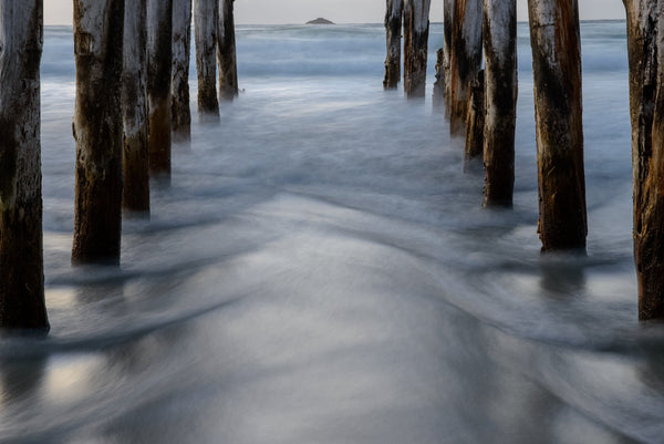 Patterns in the water as the receeding waves wrap around the breakwater poles at St Clair Beach.