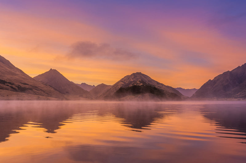 A beautiful sunrise over the calm waters of Moke Lake near Queenstown.