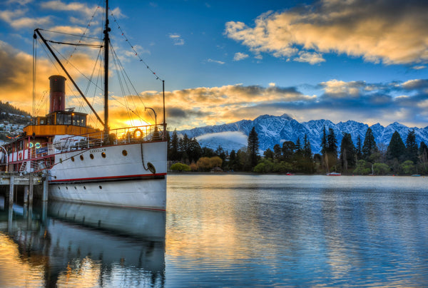 The historic TSS Earnslaw sits at dock in Queenstown Bay, Lake Wakatipu one winters morning as the sun rises above the Remarkables in the distance.