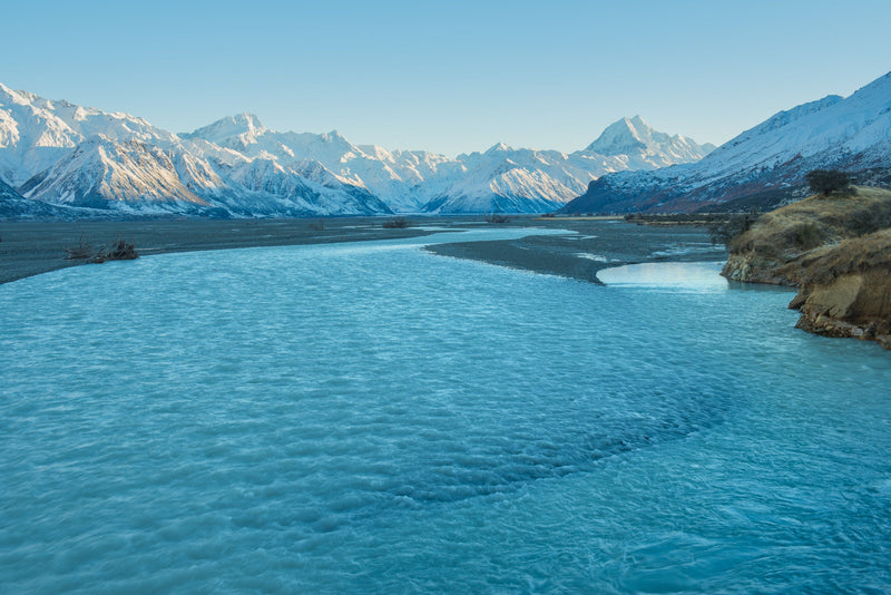 A bitterly cold morning on the banks on the Tasman River as the first light of the day slowly creeps down the Southern Alps in the distance.