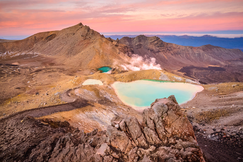 Beautiful pink hues light up the sky over the Emerald Lakes at the midway point of the Tongariro Alpine Crossing, Tongariro National Park, North Island, New Zealand