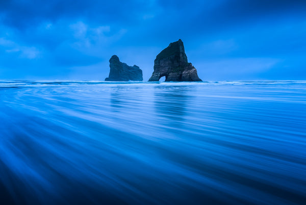An early morning long exposure of the Archway Islands at Wharariki Beach, Golden Bay with an incomming tide one gloomy winters day.  The wide flat beach make for a beautiful textural foreground.