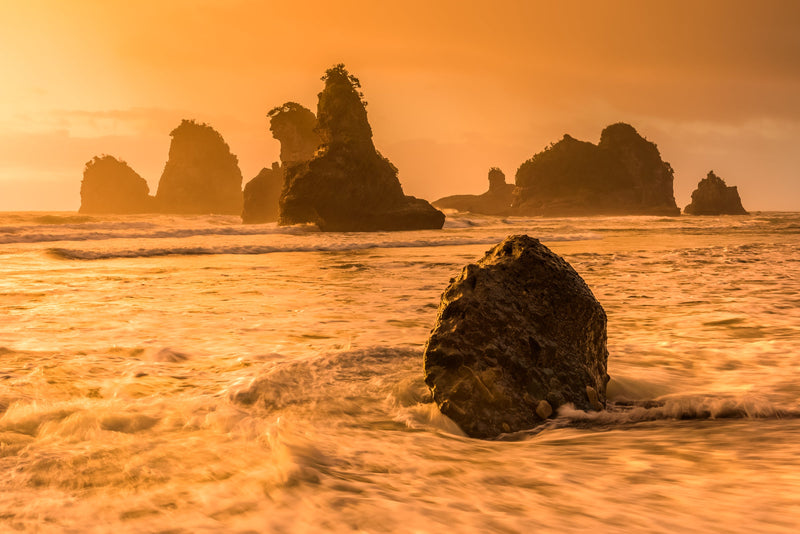 Torrential rain pounds the Tasman Sea at Motukiekie Beach as the tide rises at sunset.  West Coast rawness that creates lasting memories of the power of mother nature.